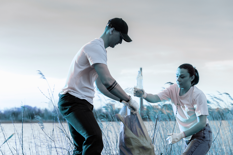 a person and a person are picking up trash in a field