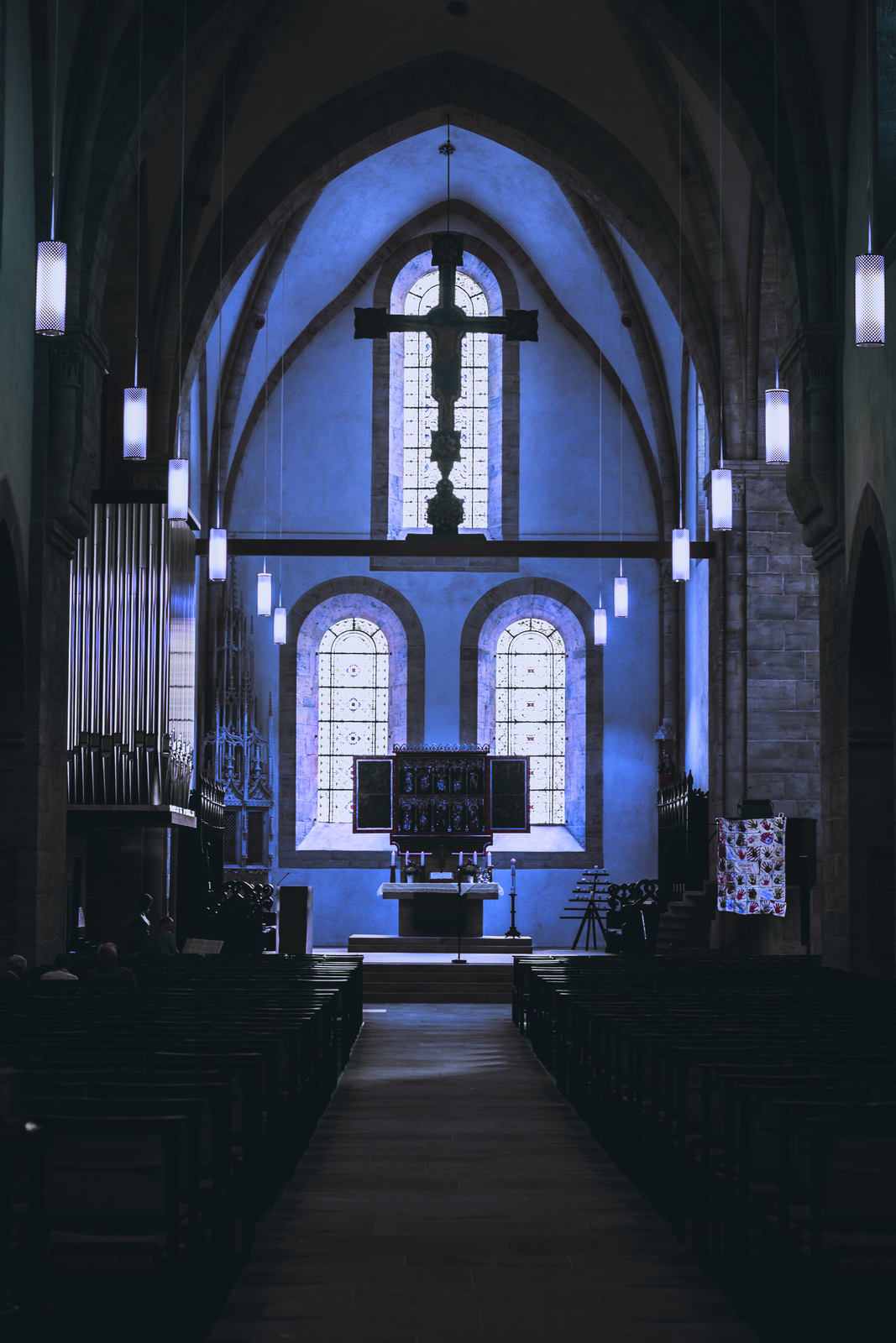 a church with stained glass windows and a cross on the wall
